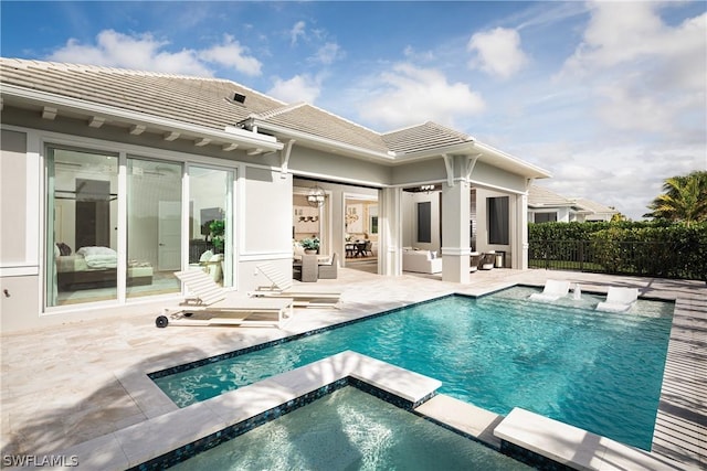 rear view of property with outdoor lounge area, a swimming pool with hot tub, and a patio