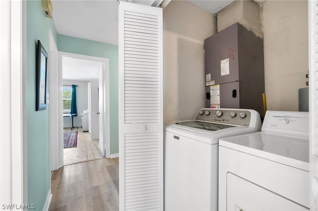 laundry area featuring separate washer and dryer and light hardwood / wood-style floors