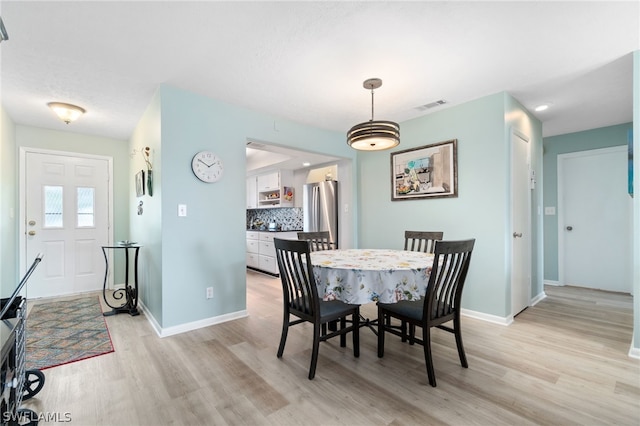 dining space with light hardwood / wood-style flooring