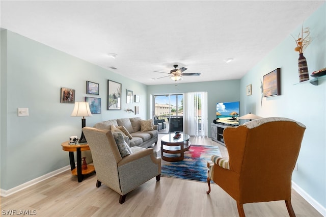 living room featuring ceiling fan and light hardwood / wood-style flooring