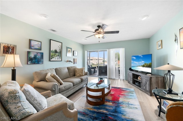 living room featuring ceiling fan and light hardwood / wood-style floors