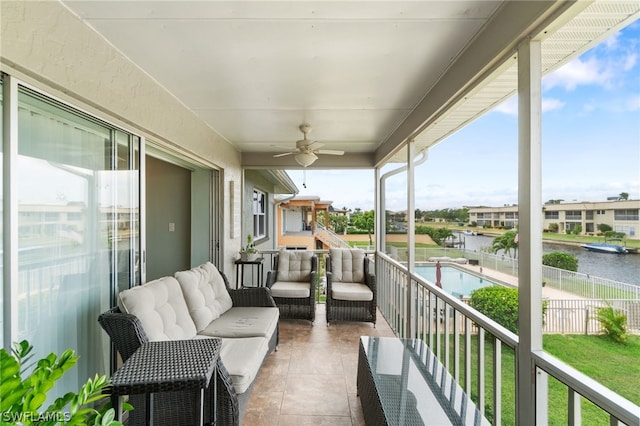 balcony featuring an outdoor living space, ceiling fan, and a water view