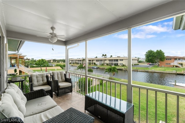 sunroom / solarium featuring ceiling fan and a water view