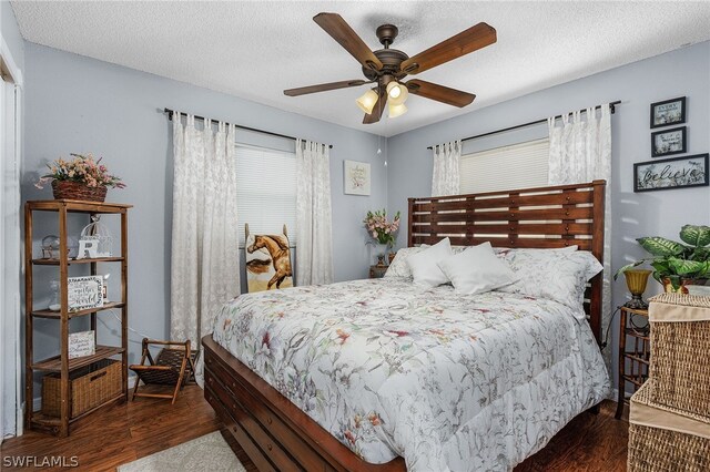 bedroom featuring ceiling fan, dark hardwood / wood-style floors, and a textured ceiling