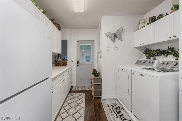 washroom featuring washing machine and dryer, cabinets, and dark hardwood / wood-style floors