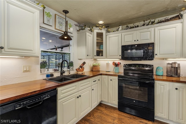 kitchen with wooden counters, sink, black appliances, pendant lighting, and dark hardwood / wood-style floors