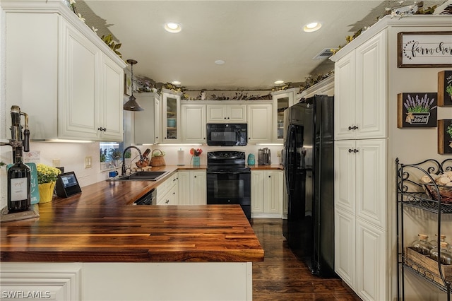 kitchen with black appliances, white cabinets, sink, and wooden counters