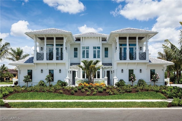 view of front of home with a balcony and a front yard