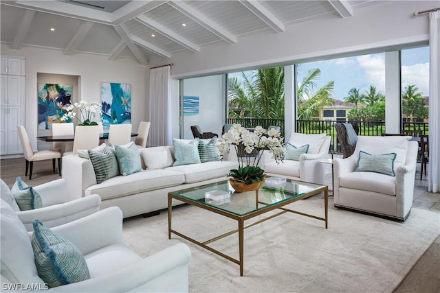 living room with vaulted ceiling with beams, plenty of natural light, and light wood-type flooring