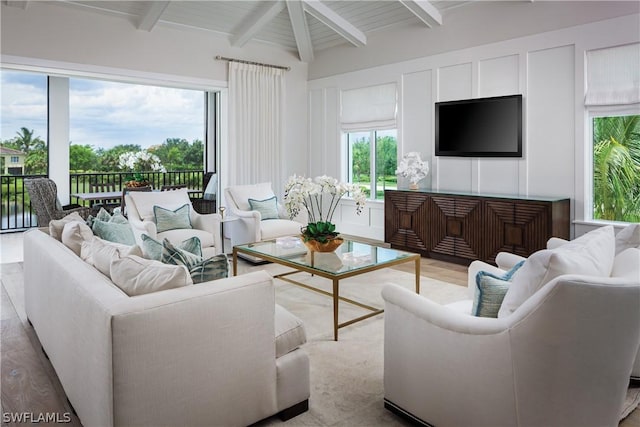 living room with beam ceiling and light wood-type flooring