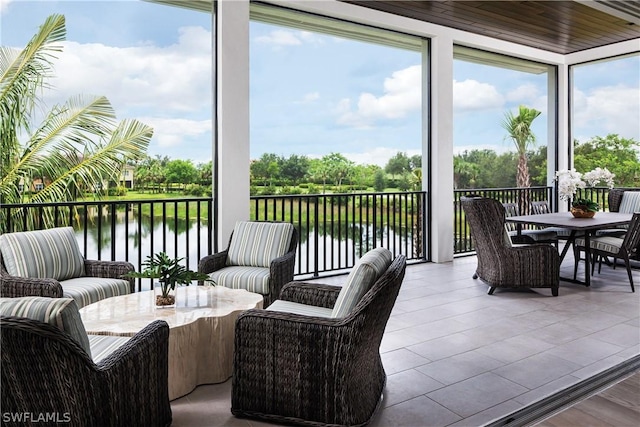 sunroom featuring a water view