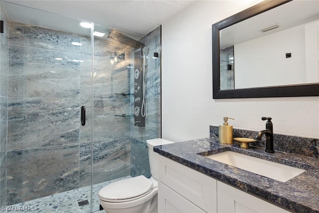 bathroom featuring vanity, toilet, and a shower with door