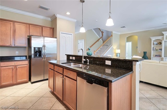 kitchen featuring sink, stainless steel appliances, dark stone counters, decorative light fixtures, and light tile patterned flooring