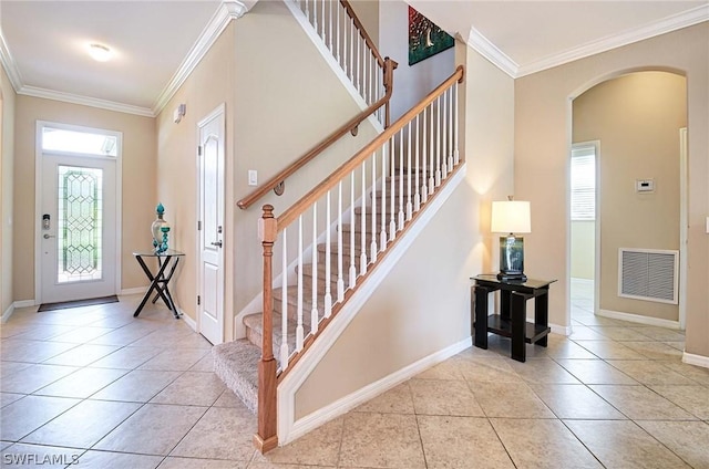 foyer featuring a wealth of natural light, light tile patterned floors, and ornamental molding