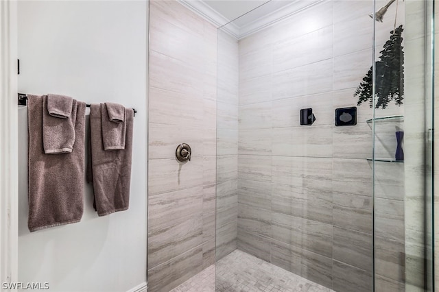 bathroom featuring ornamental molding and tiled shower