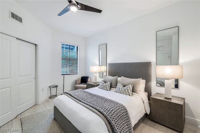 bedroom featuring a closet, light hardwood / wood-style floors, and ceiling fan