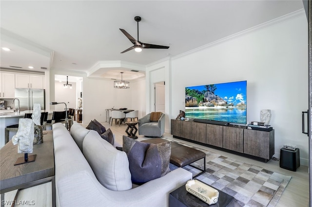 living room featuring ceiling fan with notable chandelier, sink, light wood-type flooring, and crown molding