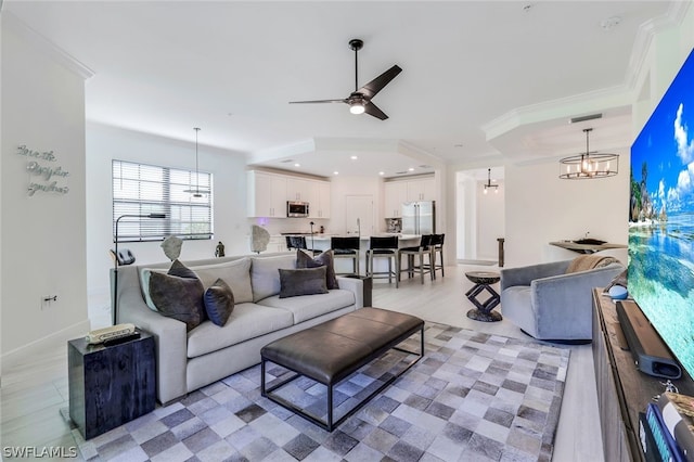 living room with crown molding, light hardwood / wood-style floors, and ceiling fan with notable chandelier