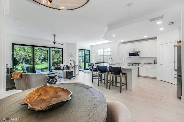 dining area with ceiling fan and sink