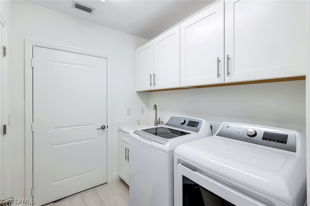 laundry room with cabinets, sink, and washer and dryer