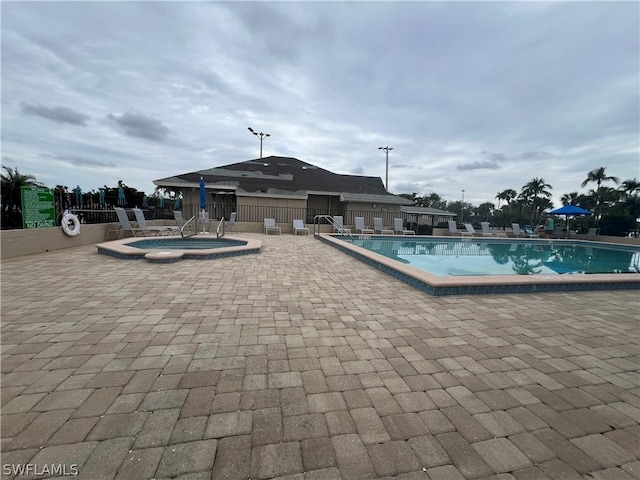 view of pool with a community hot tub and a patio area