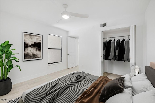 bedroom with ceiling fan, light wood-type flooring, and a closet