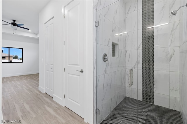 bathroom featuring a shower with door, ceiling fan, and hardwood / wood-style floors