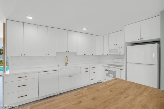 kitchen with decorative backsplash, sink, white appliances, and white cabinets