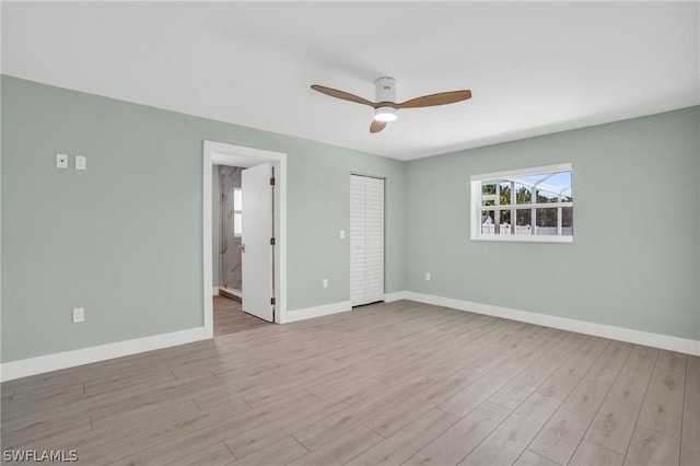 unfurnished bedroom with a closet, ceiling fan, connected bathroom, and light hardwood / wood-style flooring