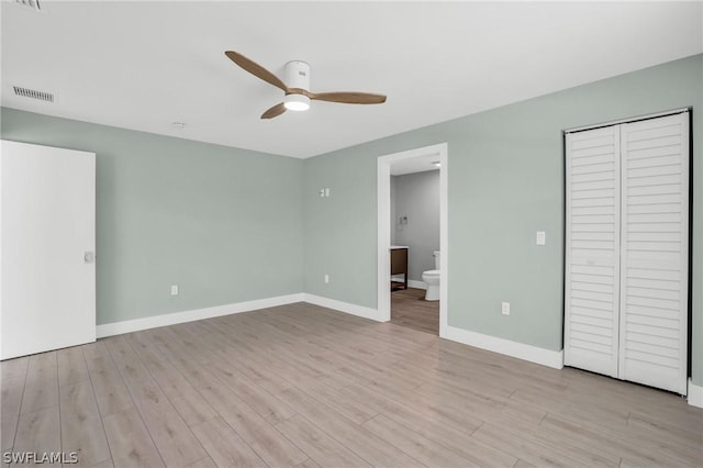 unfurnished bedroom with ceiling fan, light hardwood / wood-style floors, ensuite bathroom, and a closet