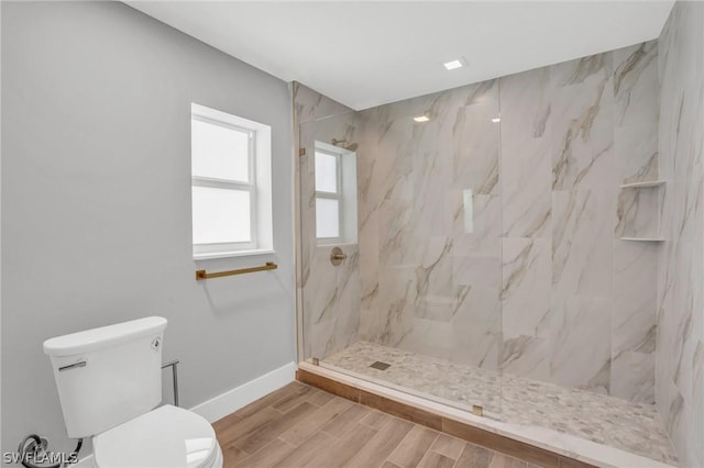 bathroom with toilet and a tile shower