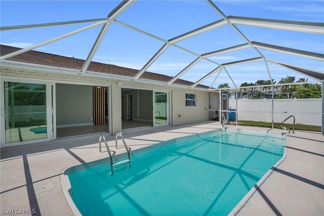 view of pool with glass enclosure and a patio area