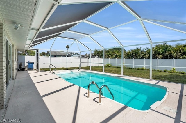 view of swimming pool featuring glass enclosure, a patio area, and a lawn