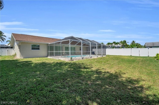 back of house featuring a fenced in pool, a lanai, and a yard