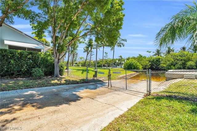 view of gate with a lawn and fence