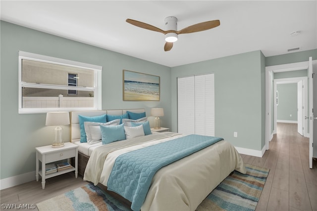 bedroom with ceiling fan, light hardwood / wood-style floors, and a closet