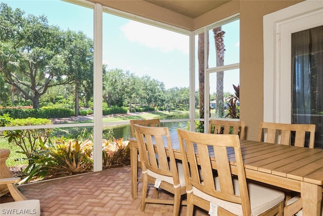 sunroom / solarium featuring a water view