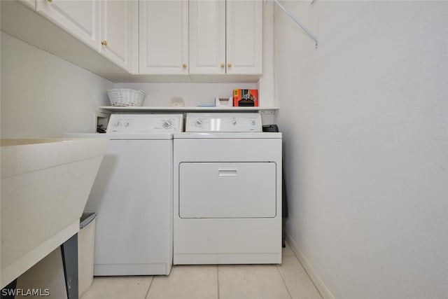 laundry area with washing machine and dryer, cabinets, light tile patterned floors, and sink