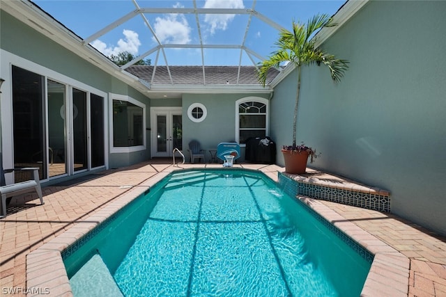 view of pool with a lanai, a patio, and french doors