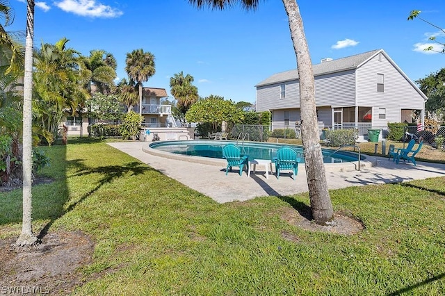 view of pool with a patio area and a yard