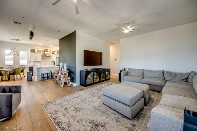 living room with ceiling fan and wood-type flooring