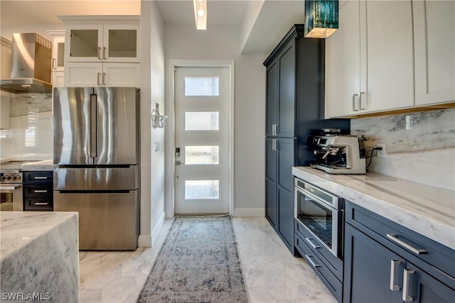 kitchen featuring white cabinetry, a healthy amount of sunlight, wall chimney exhaust hood, and appliances with stainless steel finishes