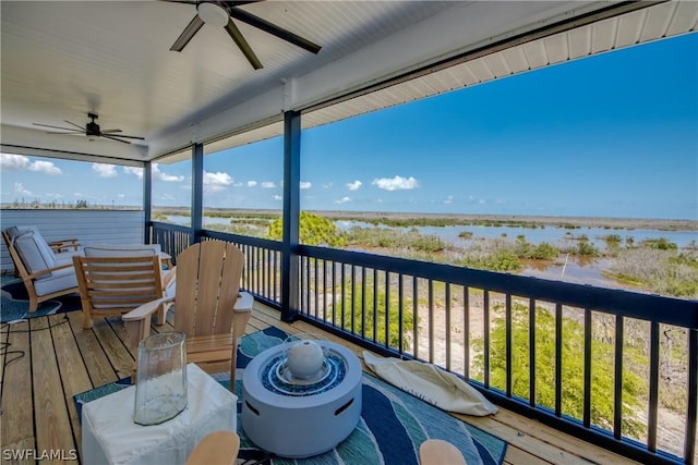 wooden terrace with ceiling fan and a water view