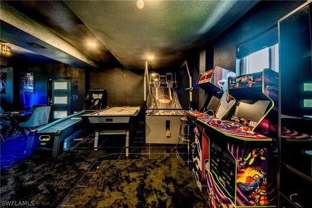 game room featuring tile floors and a textured ceiling