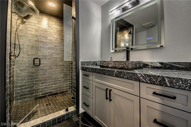 bathroom with vanity and a shower with door