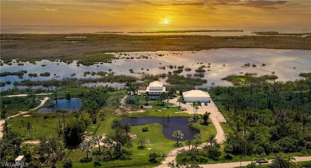 aerial view at dusk featuring a water view