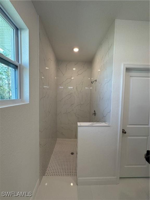 bathroom featuring a marble finish shower