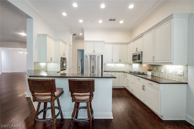 kitchen with ornamental molding, dark hardwood / wood-style flooring, backsplash, and appliances with stainless steel finishes