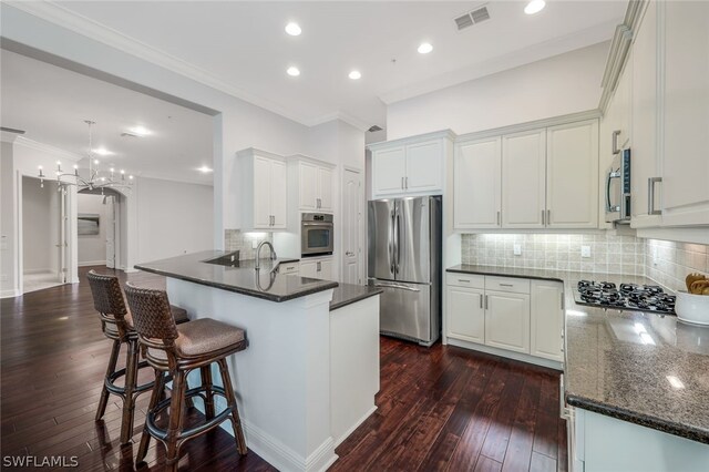 kitchen with dark hardwood / wood-style flooring, kitchen peninsula, tasteful backsplash, appliances with stainless steel finishes, and a breakfast bar