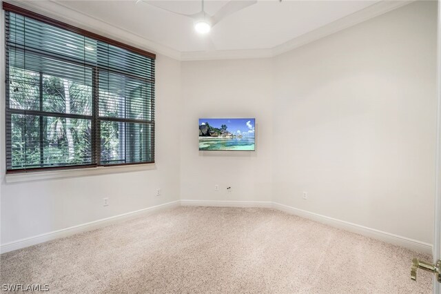 carpeted empty room featuring crown molding and baseboards